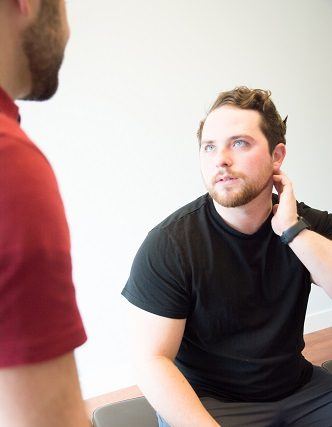 Dr. Stewart of New Leaf Chiropractic listens to a patient share their symptoms.