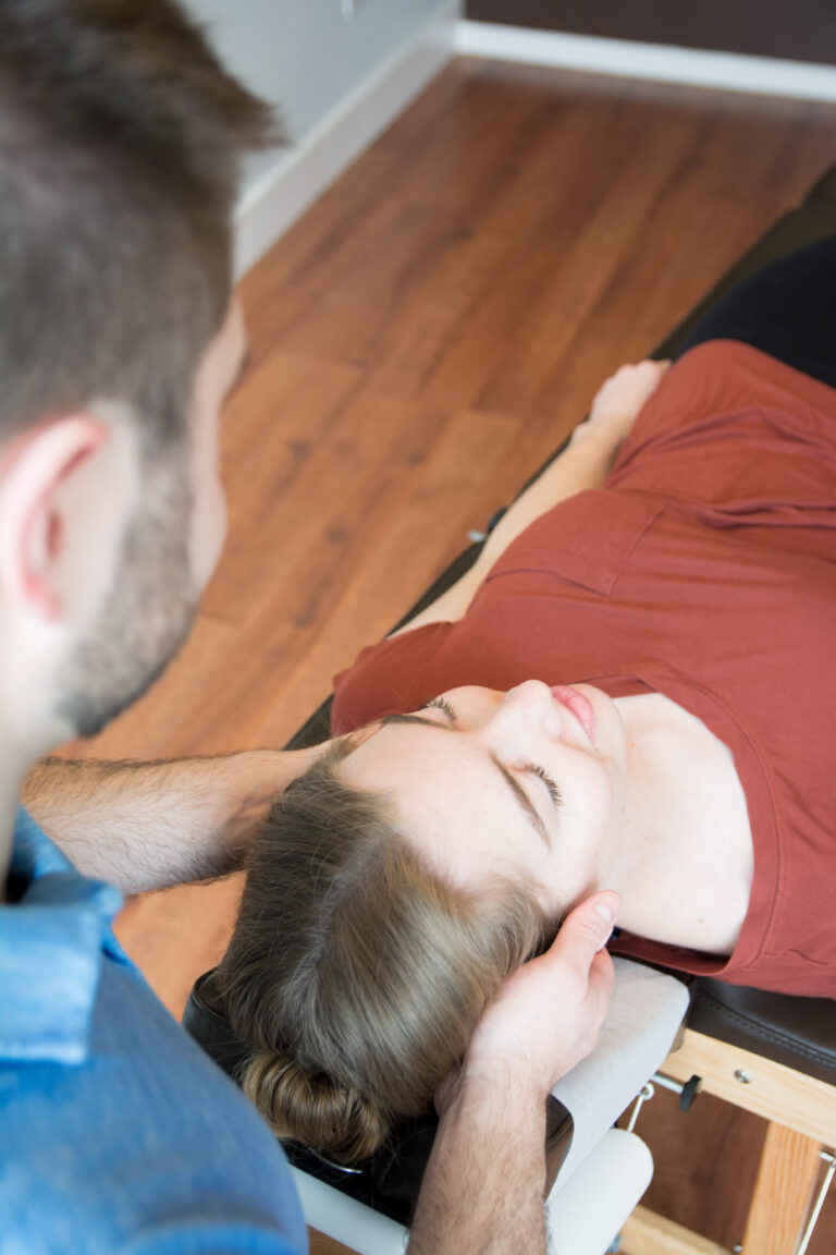 Dr. Mason Stewart, DC of New Leaf House Call Chiropractic in Post Falls, ID provides Chiropractic Care by adjusting the neck of a female patient.