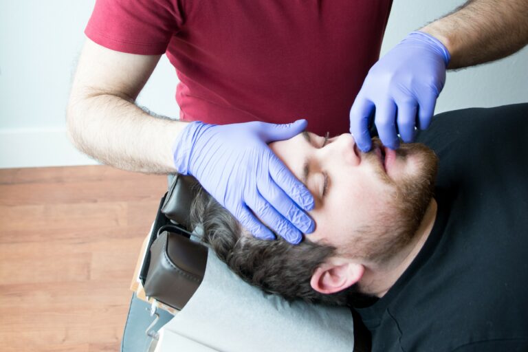 Dr. Mason Stewart, DC of New Leaf House Call Chiropractic in Post Falls, ID conducts a Nasal Specific Technique treatment on a male patient.