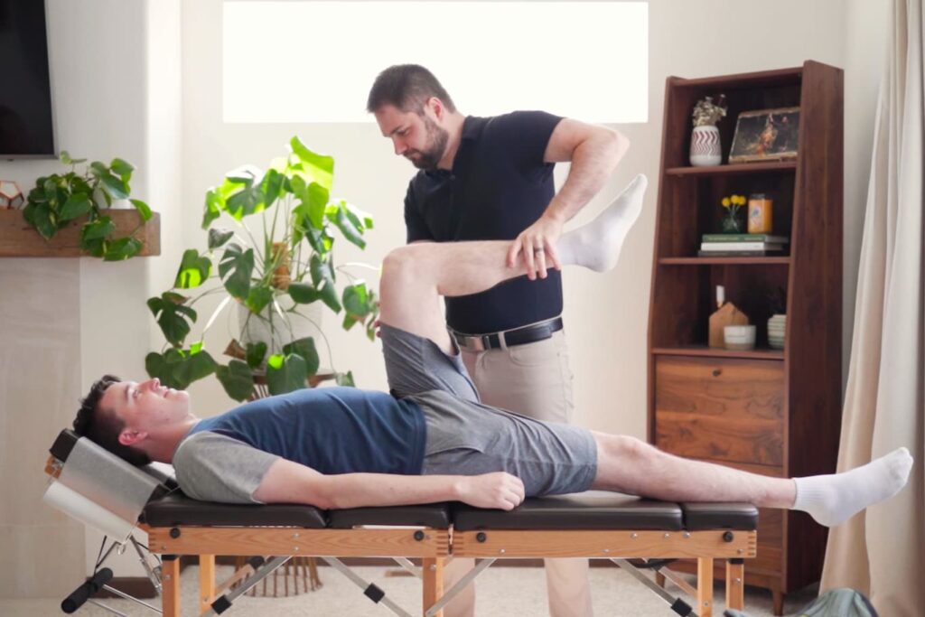 Dr. Mason Stewart tests a male patient's leg muscle.